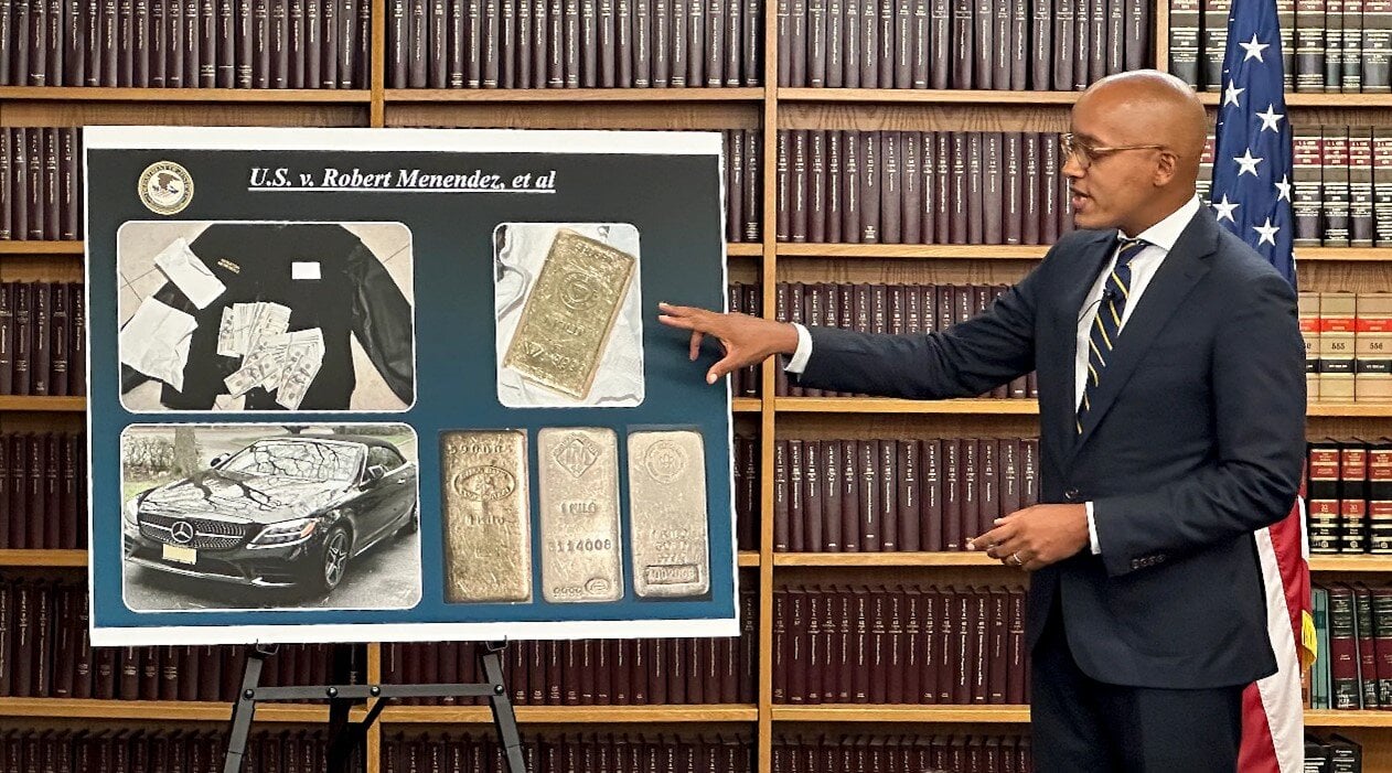 Cash, gold bars, and a Mercedes Benz found in Senator Robert Menendez's home, as displayed by the District Attorney, Southern District of New York, during a press conference.